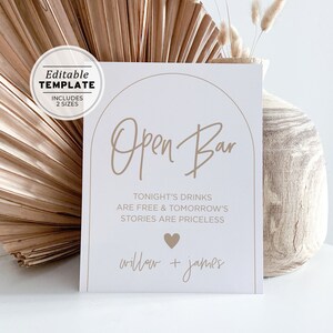 May include: A printable sign with a tan background and brown text that reads "Open Bar" with the text "Tonight's drinks are free & tomorrow's stories are priceless" and "willow + james" below. The sign is designed for a wedding or other celebration.