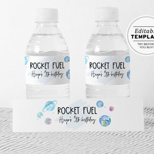 May include: Editable water bottle labels with a space theme. The labels feature a blue watercolor background with planets and the text "ROCKET FUEL" and "Hago's 5th birthday".