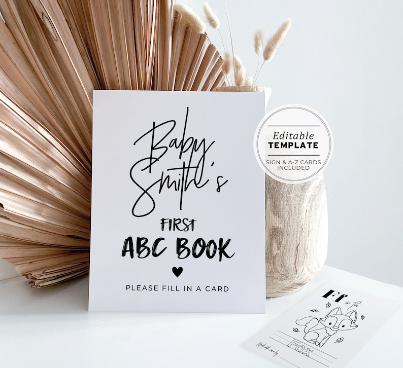 May include: A printable sign for a baby shower or baby's first birthday party. The sign says "Baby Smith's First ABC Book" with a heart symbol and the text "Please fill in a card". The sign is white with black text and is an editable template with A-Z cards included.