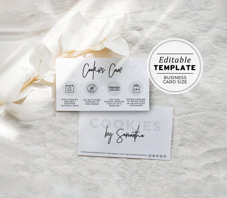 May include: A white business card with black text that reads "Cookies Cave" and includes instructions for storing cookies. The card also includes the text "Cookies by Samantha" and a website address.