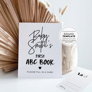 May include: A white sign with black text that reads "Baby Smith's First ABC Book" with a heart symbol. The sign also says "Please fill in a card". The sign is an editable template with sign and A-Z cards included.