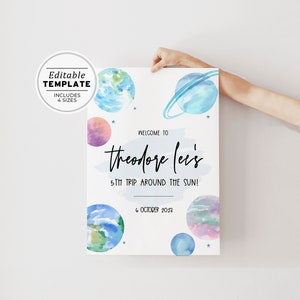 Peut inclure: Une affiche d'anniversaire imprimable avec une illustration aquarelle de planètes et d'étoiles. Le texte indique "Bienvenue à Theodore Lei's 5th Trip Around the Sun! 6 octobre 2023".