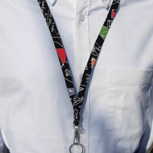 May include: A black and white lanyard with mathematical equations and symbols. The lanyard has a silver clip and a silver ring.