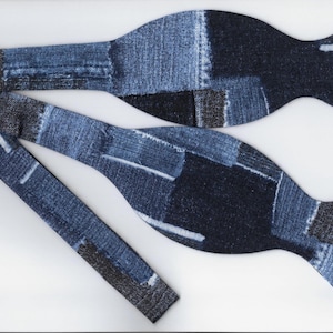 Puede incluir: Una pajarita azul hecha de tela vaquera con un diseño de patchwork.