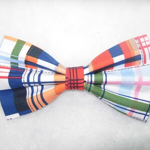 May include: A bow tie with a plaid pattern in shades of blue, orange, green, red, and white.