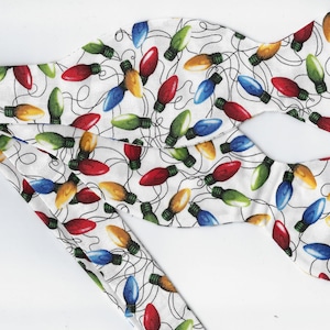 May include: A white bow tie with a pattern of colorful Christmas lights. The lights are red, green, blue, and yellow.