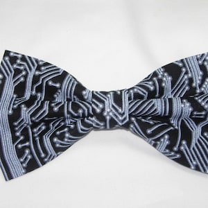 Op de afbeelding: Een zwarte strik met een wit printpatroon van een printplaat.