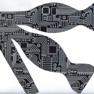 May include: A black bow tie with a white circuit board pattern.