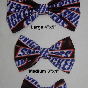 Puede incluir: Tres lazos para el pelo de diferentes tama&ntilde;os, hechos de tela con un patr&oacute;n de barra de chocolate. Los lazos est&aacute;n etiquetados como "Large 4"x5"", "Medium 3"x4"" y "Small 2.5"x3"".