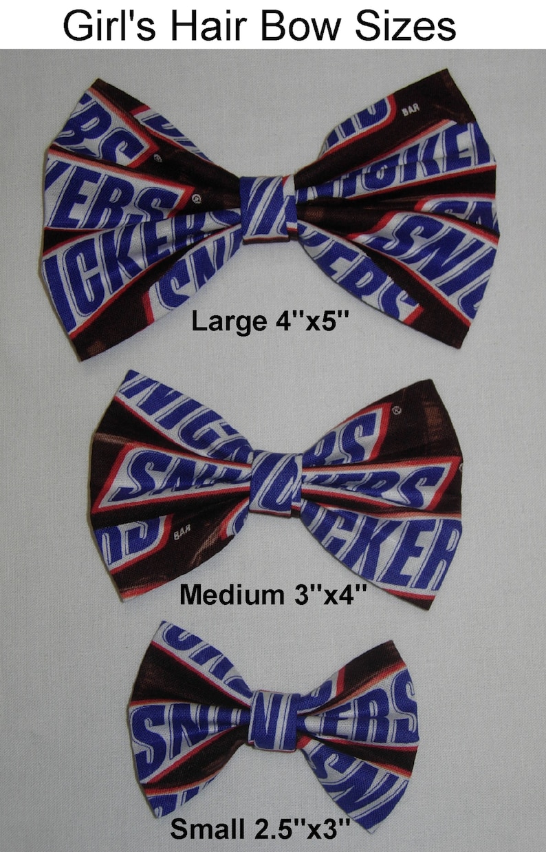 Puede incluir: Tres lazos para el pelo de diferentes tama&ntilde;os, hechos de tela con un patr&oacute;n de barra de chocolate. Los lazos est&aacute;n etiquetados como "Large 4"x5"", "Medium 3"x4"" y "Small 2.5"x3"".
