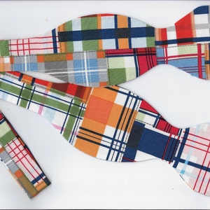 May include: Two bow ties made from patchwork fabric with a variety of colors and patterns, including red, orange, green, blue, and white.