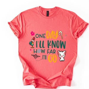 May include: A coral pink t-shirt with a green, yellow, and blue graphic print featuring a rooster, a butterfly, and a pig. The text on the shirt reads "One Day I'll Know How Far I'll Go."