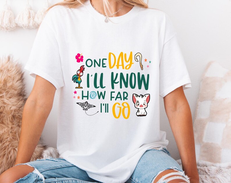 May include: White t-shirt with a graphic print of a rooster, a pig, a seashell, and a star. The text on the shirt reads "One Day I'll Know How Far I'll Go."