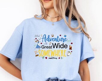 May include: Light blue t-shirt with the text "I Want Adventure in the Great Wide Somewhere" and various cartoon illustrations. The design includes images of a book, rose, and characters from a popular animated film.