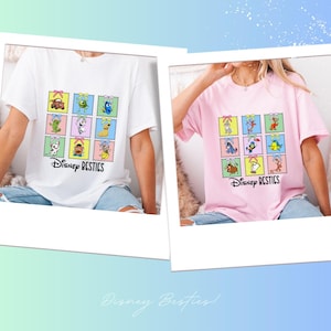 Puede incluir: Dos camisetas, una blanca y otra rosa, cada una con un gráfico colorido de personajes de Disney dispuestos en cuadrados tipo sello postal. El texto "Disney Besties" está impreso debajo del gráfico en cada camiseta.