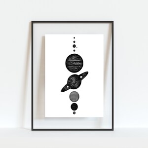 May include: A black and white illustration of the solar system with planets and stars in a framed print.