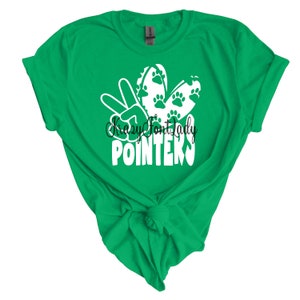 May include: Green t-shirt with a white peace sign and paw prints. The text "Crazy Font Lady" and "Pointers" is printed on the shirt.
