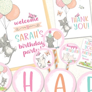 May include: Pink and blue birthday party decorations with a cat theme. The decorations include a welcome sign, thank you tags, and a happy birthday banner. The text on the welcome sign reads "Welcome to Sarah's birthday party".