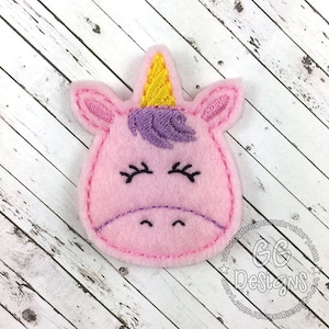 May include: Pink felt unicorn applique with a yellow horn, purple mane, and embroidered eyes and mouth.