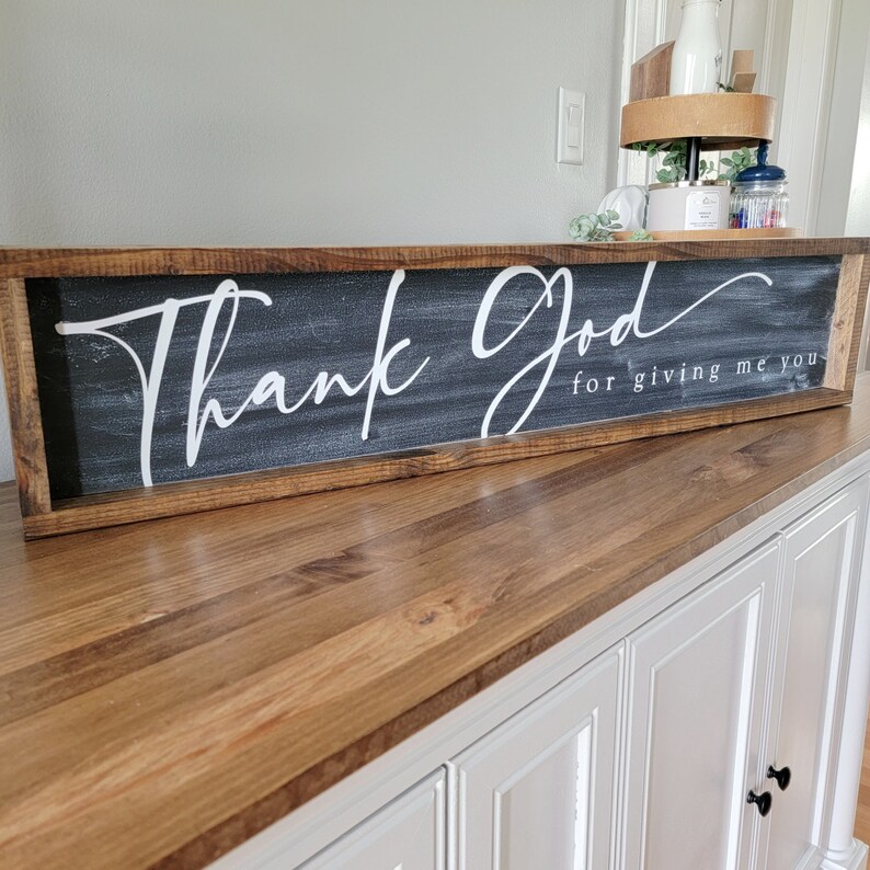 May include: A wooden framed sign with a black background and white lettering that reads "Thank God for giving me you".