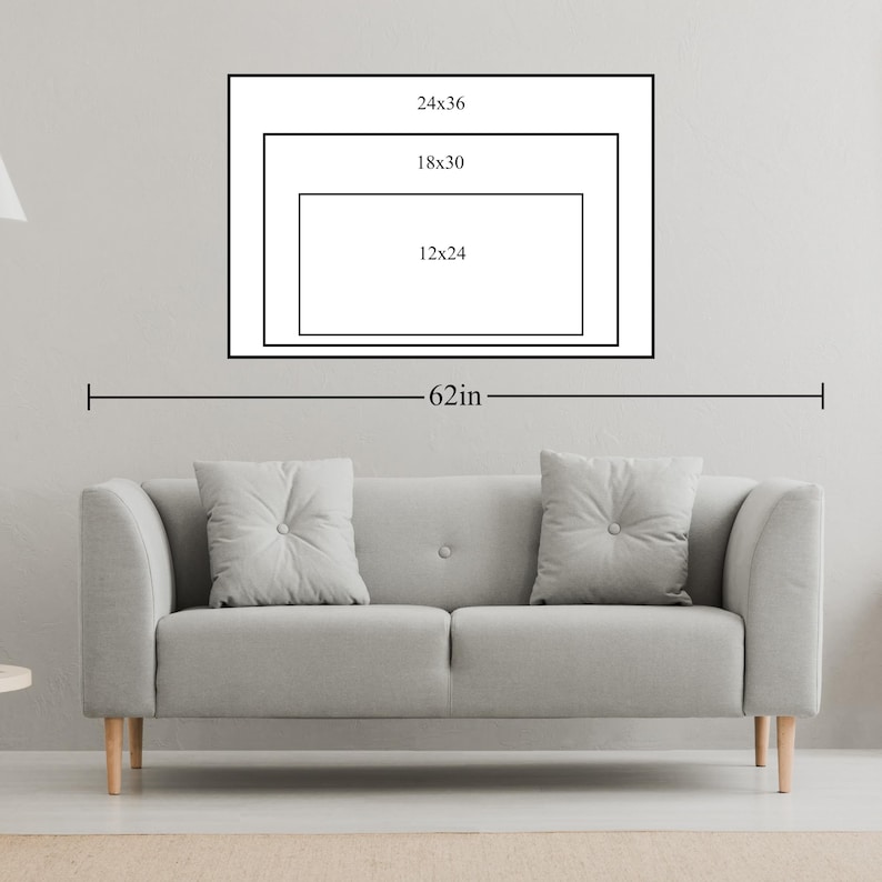 May include: A gray sofa with two button-tufted pillows is positioned below a wall art display. The art features three nested rectangular frames with dimensions labeled as 24x36, 18x30, and 12x24 inches. The overall width is labeled as 62 inches.
