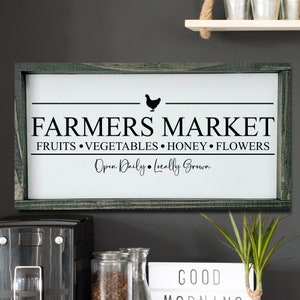 K&ouml;nnte beinhalten: Ein wei&szlig;es Schild mit schwarzem Text, auf dem steht "Farmers Market Fruits Vegetables Honey Flowers Open Daily Locally Grown". Das Schild ist in einen dunkelgr&uuml;nen Holzrahmen gefasst und hat eine schwarze Silhouette eines Huhns &uuml;ber dem Text.