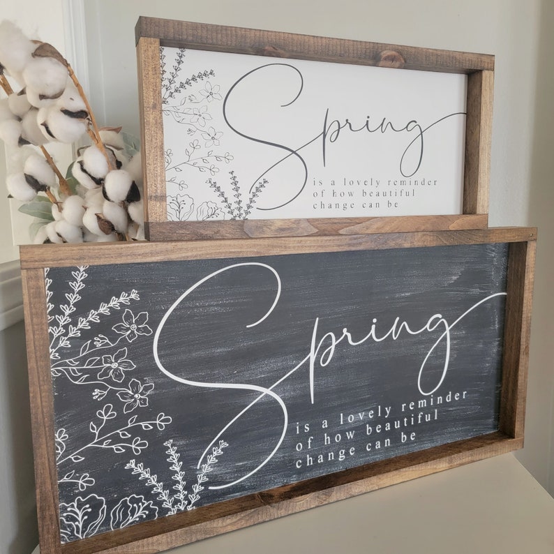 May include: Two wooden signs with a black and white floral design and the text "Spring is a lovely reminder of how beautiful change can be".