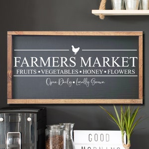 K&ouml;nnte beinhalten: Ein schwarzes Schild aus Schiefer mit einem Holzrahmen, auf dem der Text "Farmers Market" mit einer wei&szlig;en Silhouette eines Huhns steht. Das Schild enth&auml;lt auch den Text "Obst, Gem&uuml;se, Honig, Blumen" und "T&auml;glich ge&ouml;ffnet, lokal angebaut".