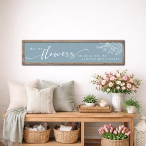 May include: A white ceramic mug with a black handle and the text "But First, Coffee" in a black, bold font. The mug is on a white surface. The mug is approximately 10 cm tall.