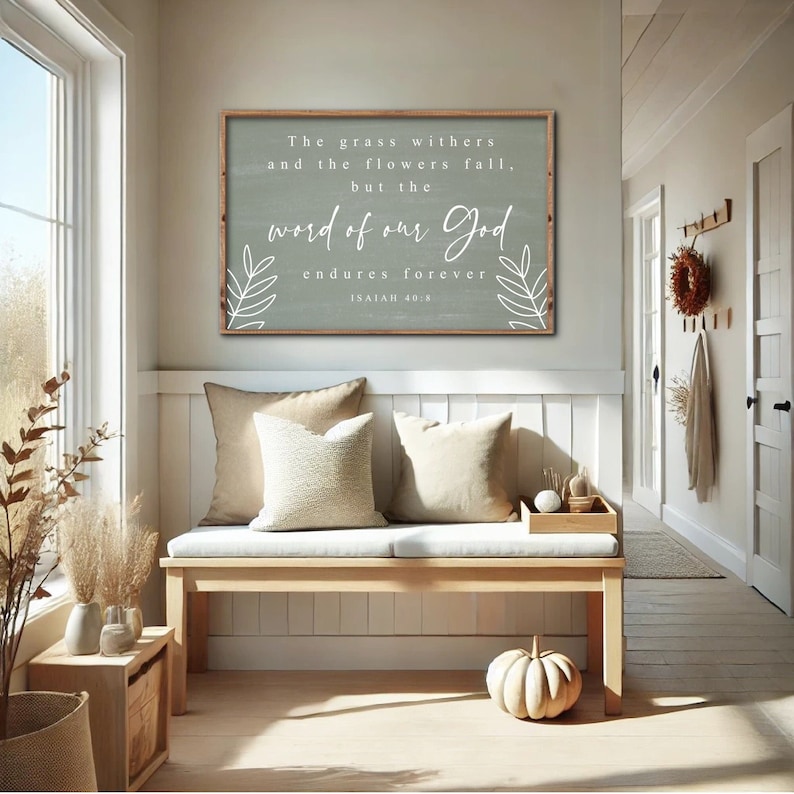 May include: A wooden sign with a light green background and white text. The sign reads "The grass withers and the flowers fall, but the word of our God endures forever Isaiah 40:8". The sign is hanging on a white wall in a home.