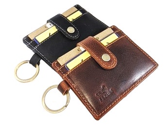 May include: Two leather card holders with key rings. One is black and the other is brown. Both have a flap with a button closure. The brown one has the text "RFID Secure" embossed on the front.