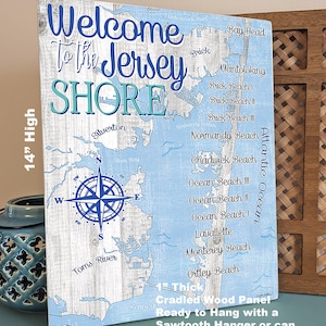 Puede incluir: Un letrero de madera de 35,5 cm por 27,9 cm con un mapa azul y blanco de la costa de Jersey. El letrero tiene el texto "Welcome to the Jersey Shore" en letras azules y blancas. Una br&uacute;jula se encuentra en el centro del mapa. El letrero tiene un grosor de 2,5 cm y est&aacute; listo para colgar con un colgador de dientes de sierra o para apoyarse en un estante.
