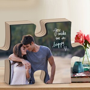 May include: A wooden puzzle piece shaped like a heart with a photo of a couple on a beach. The text "You make me so happy" is written on the puzzle piece.