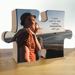 May include: A wooden jigsaw piece with a photo of a couple embracing on a beach. The other piece has the text "I never want to stop making memories with you".