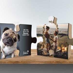 K&ouml;nnte beinhalten: Ein Holzpuzzle mit zwei Teilen. Ein Teil zeigt einen Mops mit dem Text "Some things just fill your heart without trying." und "Dolce". Der andere Teil zeigt ein Paar, das sich unter einem Blumenbogen verlobt.