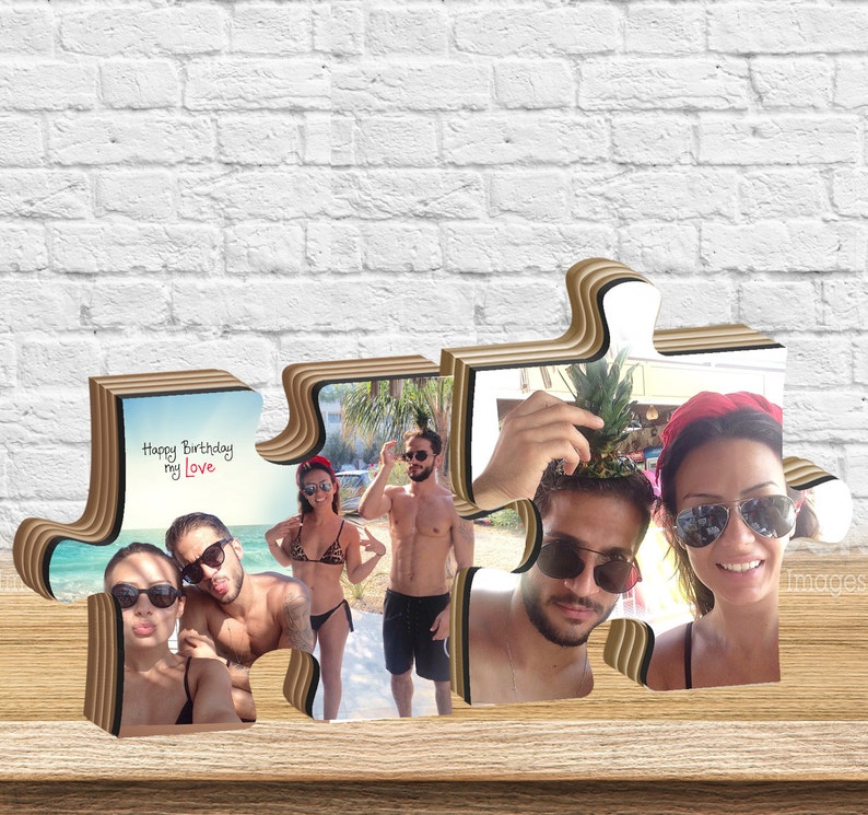 K&ouml;nnte beinhalten: Ein Holzpuzzle-Rahmen mit vier Fotos eines Paares. Die Puzzleteile sind herzf&ouml;rmig und die Fotos zeigen das Paar in verschiedenen Umgebungen. Der Text "Happy Birthday my Love" ist auf einem der Puzzleteile geschrieben.