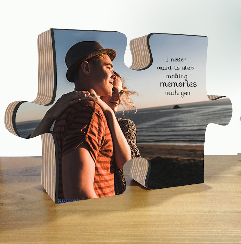 May include: A wooden jigsaw piece with a photo of a couple embracing on a beach. The other piece has the text "I never want to stop making memories with you".
