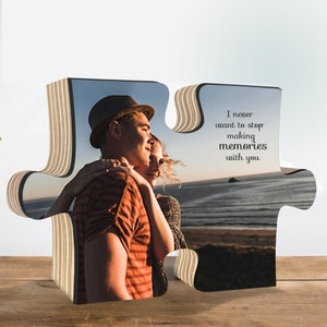 K&ouml;nnte beinhalten: Ein Holzpuzzle-Teil mit einem Foto eines Paares, das sich an einem Strand umarmt. Der Text "Ich m&ouml;chte nie aufh&ouml;ren, Erinnerungen mit dir zu schaffen" ist auf der rechten Seite des Puzzle-Teils gedruckt.