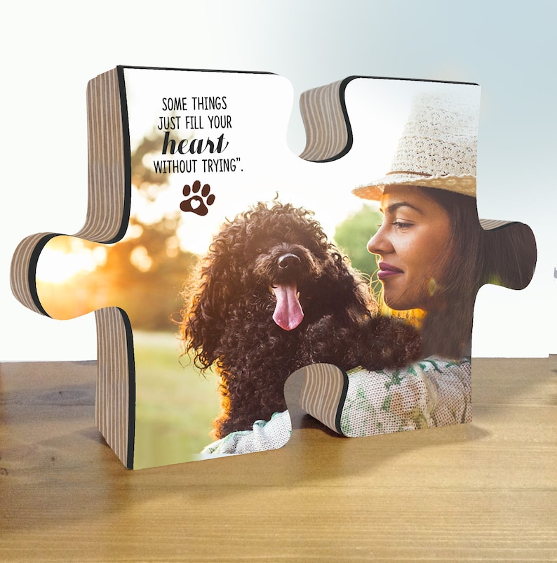 May include: A wooden puzzle shaped like two puzzle pieces with a photo of a woman and her dog. The text on the puzzle reads "Some things just fill your heart without trying."