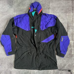 May include: A white ceramic mug with a black handle and the text "But First, Coffee" in a black, bold font. The mug is on a white surface.