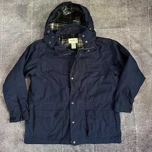 May include: Navy blue hooded jacket with a plaid-lined hood and interior. The jacket features a zipper closure, snap buttons, and multiple pockets. A classic outerwear piece for various weather conditions.