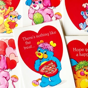 May include: Valentine's Day greeting cards featuring cartoon bears with heart-shaped designs. One card has the text "There's nothing like the treat..." and a blue bear holding a heart-shaped box of chocolates. Other cards show bears with hearts.