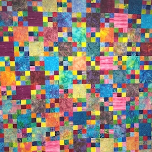 May include: A colorful patchwork quilt with a vibrant mix of squares in various colors, including blue, pink, yellow, and purple. The quilt features a repeating pattern of larger squares with smaller squares in the corners, creating a visually appealing design.