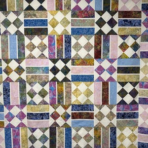 May include: A quilt featuring a repeating geometric pattern of alternating blocks. One block type consists of four small squares arranged in a diamond shape with white borders, while the other features vertical rectangular fabric strips.