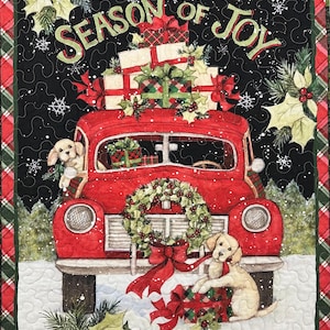 May include: A red vintage car with a wreath on the front bumper is piled high with wrapped gifts. The car is driving through a snowy scene with the words "Season of Joy" above it. Two dogs are peeking out of the car windows.