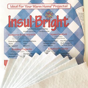 May include: A package of Insul-Bright needled insulated lining, a white material used for various home projects. The package features a blue and white checkered background with the brand name and a sun graphic. The package lists various uses for the lining, including conserving body warmth, home comfort, and creative projects.