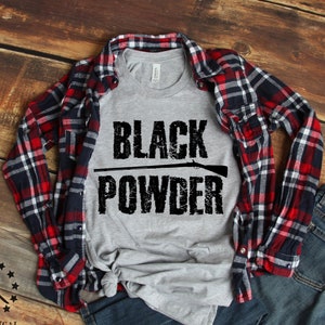 May include: A gray t-shirt with the text "BLACK POWDER" in black with a stylized image of a rifle barrel above the text.