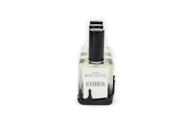 Peut inclure: Un ensemble de quatre flacons en verre transparent avec des bouchons et des &eacute;tiquettes noirs. Les flacons sont dispos&eacute;s en rang&eacute;e et reposent sur une surface noire. Les &eacute;tiquettes indiquent "Wax Poetic" et "Ember".