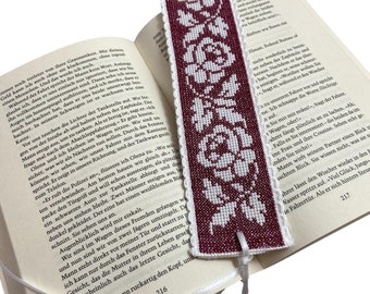 Embroidered bookmark with roses on the background in burgundy