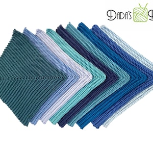 Op de afbeelding: Een set van acht gehaakte ovenwanten in tinten blauw en groen. De ovenwanten zijn in een waaier vorm gerangschikt, met de donkerste blauwe aan de onderkant en de lichtste groene aan de bovenkant.